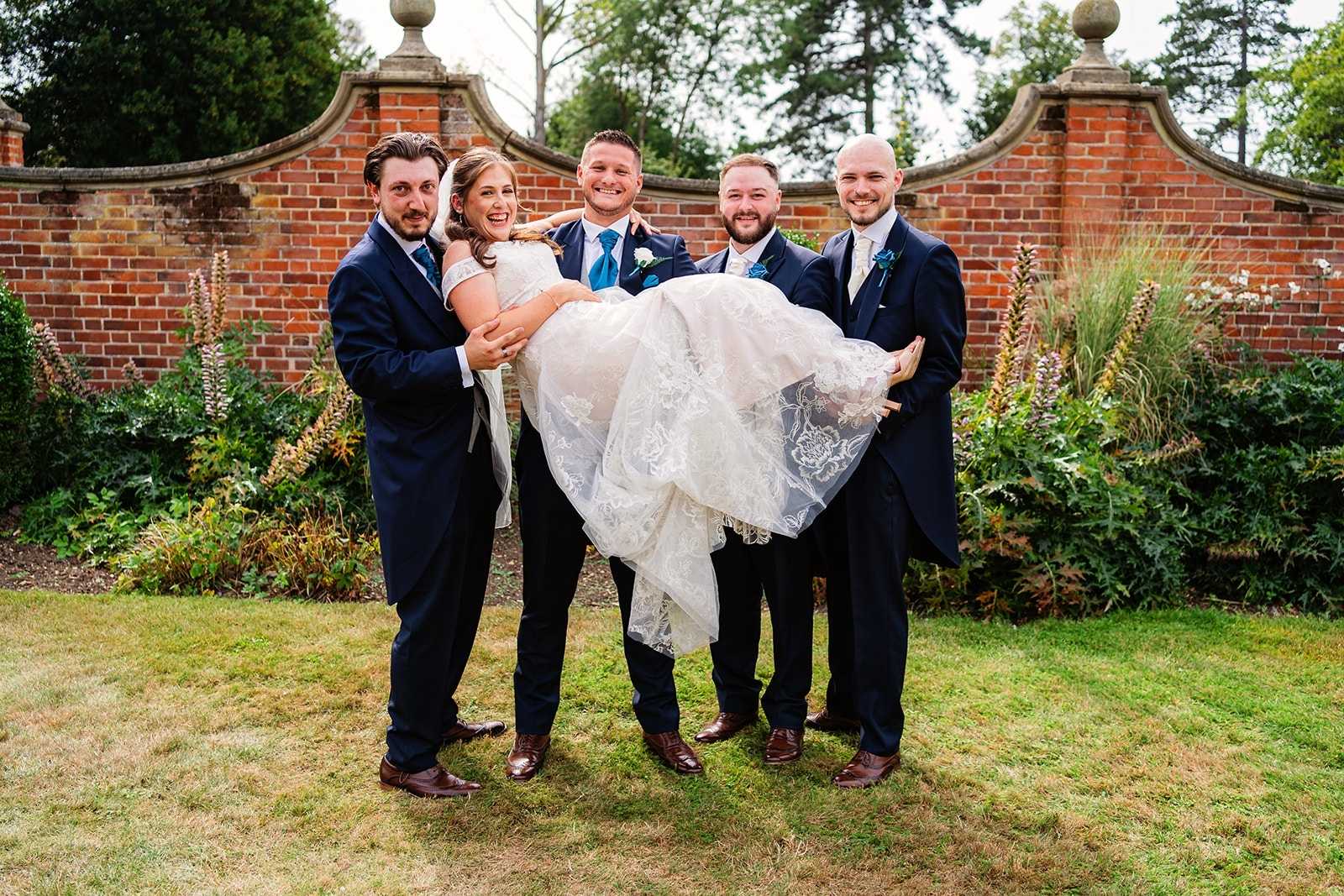 four grooms men lift the bride into a laying position