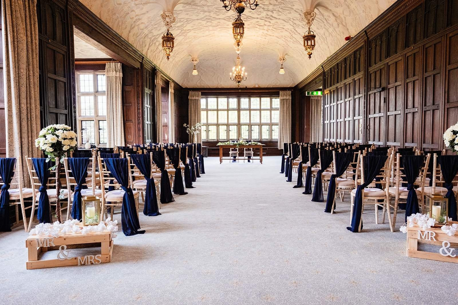 seats all set up for a ceremony with navy sways on.