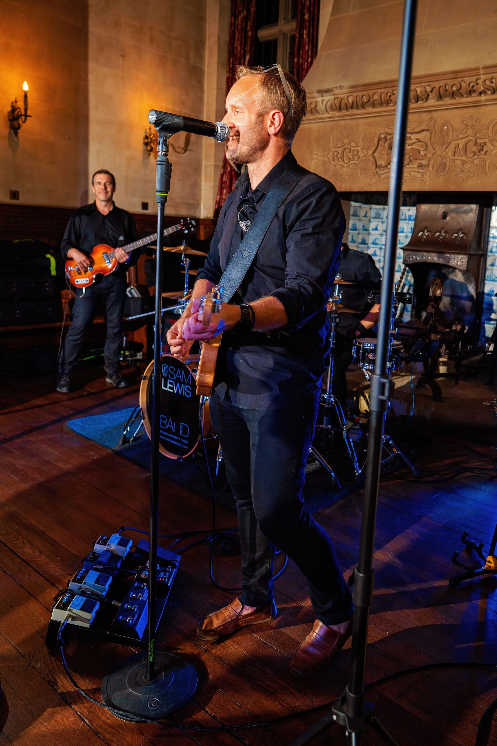 photo of sam lewis playing his guitar at a wedding