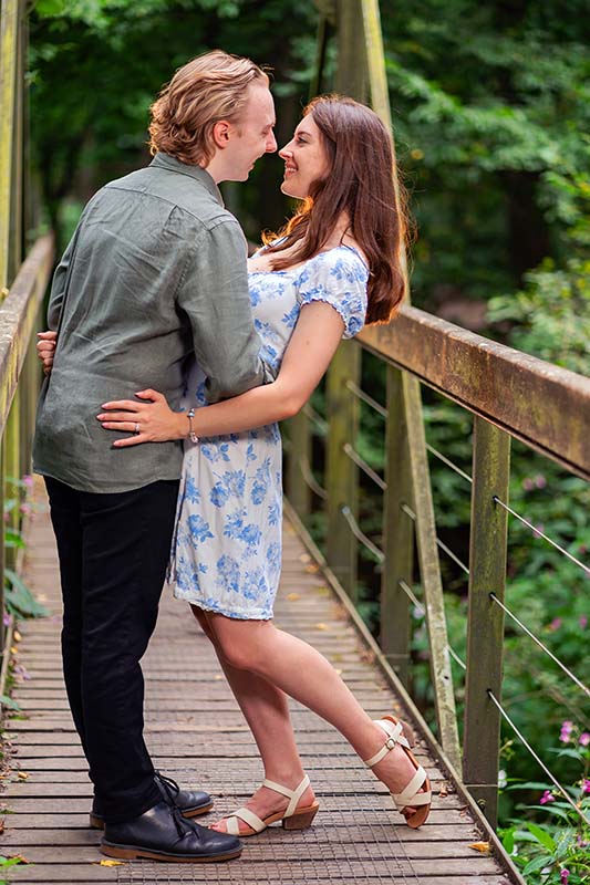 hertfordshire engagement shoot in a local woodland. couple standing on bridge.
