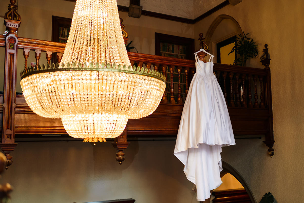 bridal prep - wedding dress hanging on the oak staircase