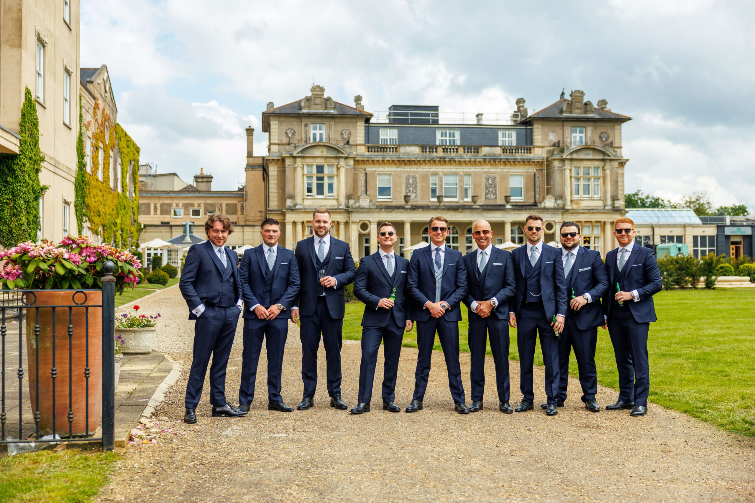 down hall weddings - groom and groomsmen stand in a line in front down hall