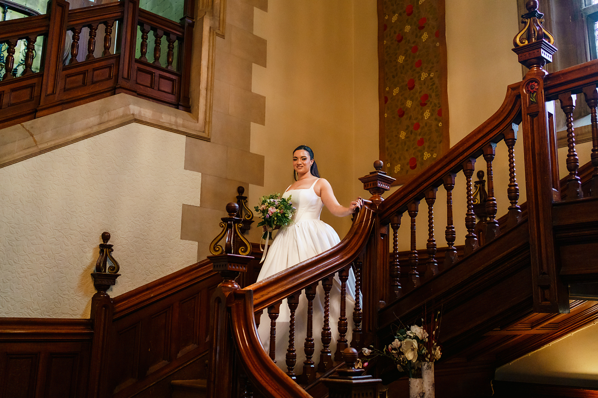 pendley manor - bride gliding down the oak stair case