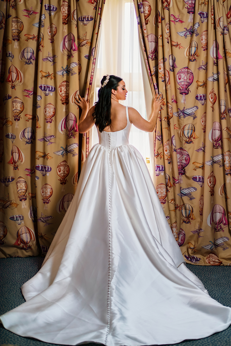 pendley manor wedding photographer - bride opening curtains