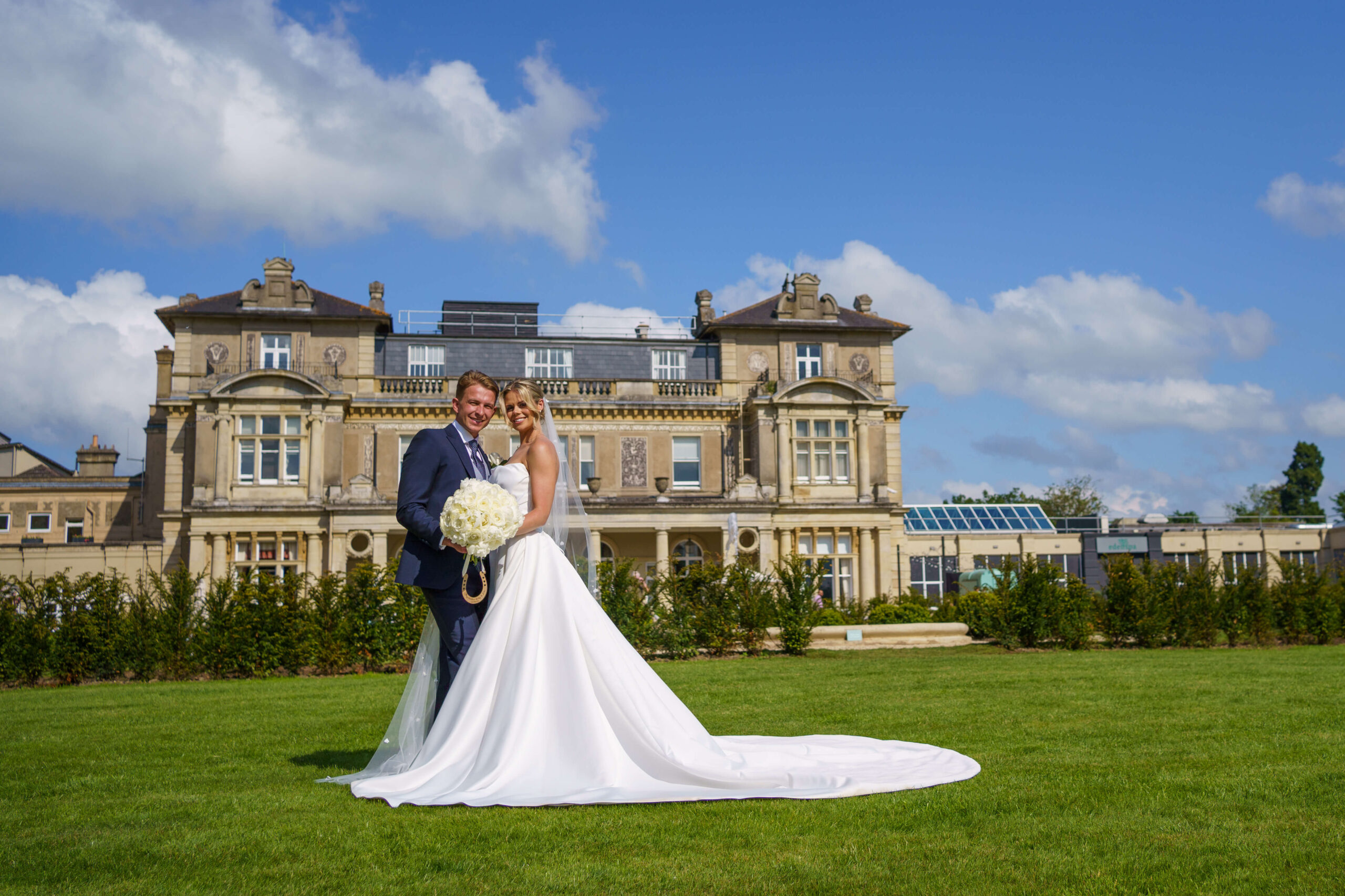 down hall weddings - bride and groom stand in front of down hall