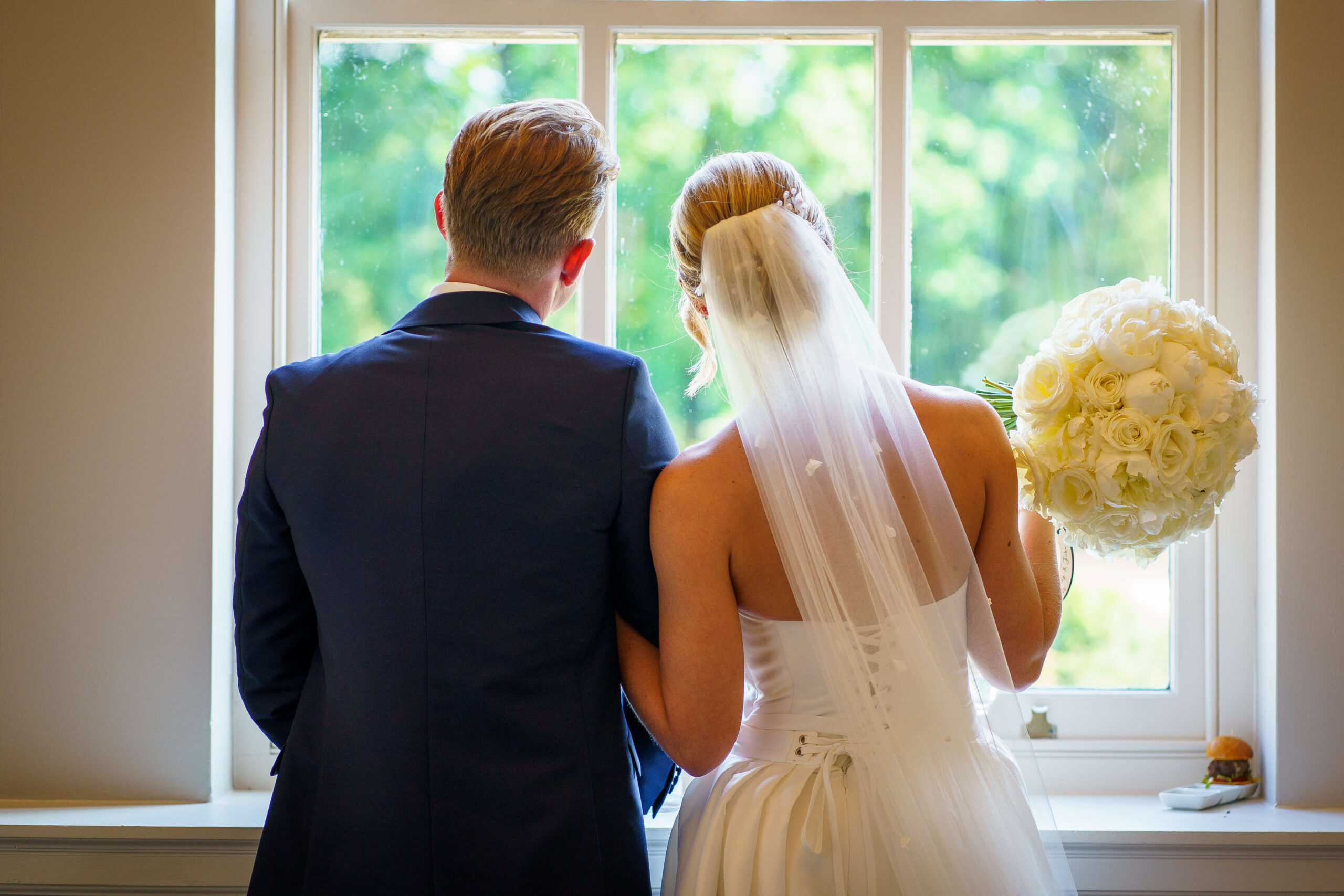 down hall weddings - bride and groom look out of the window