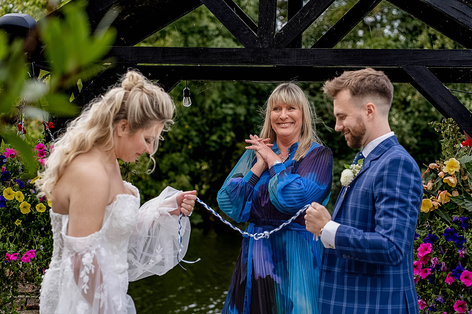 bride, groom and celebrant at a handfasting ceremony