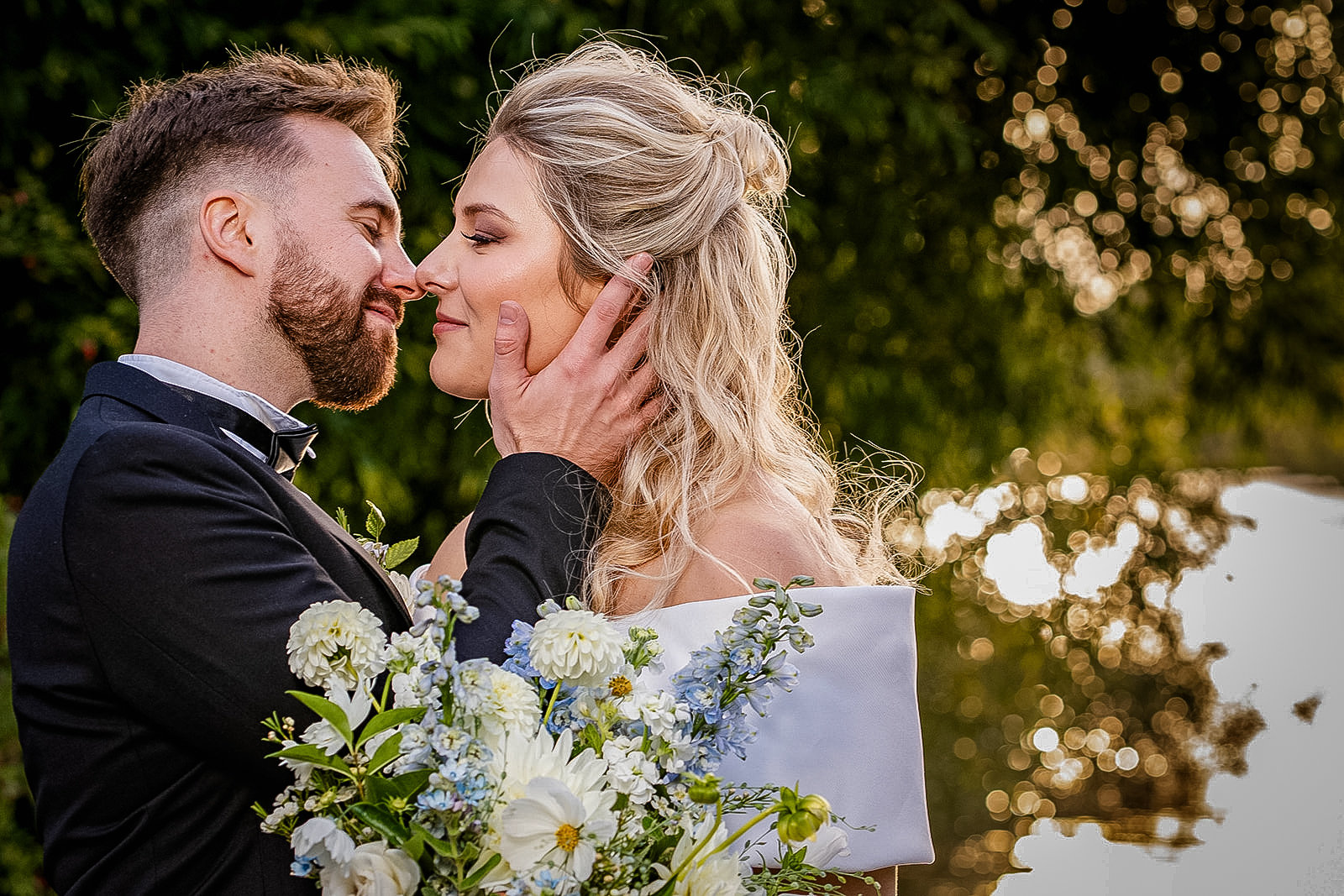 bride and groom embracing by river at golden hour, bedfordshire wedding photographer