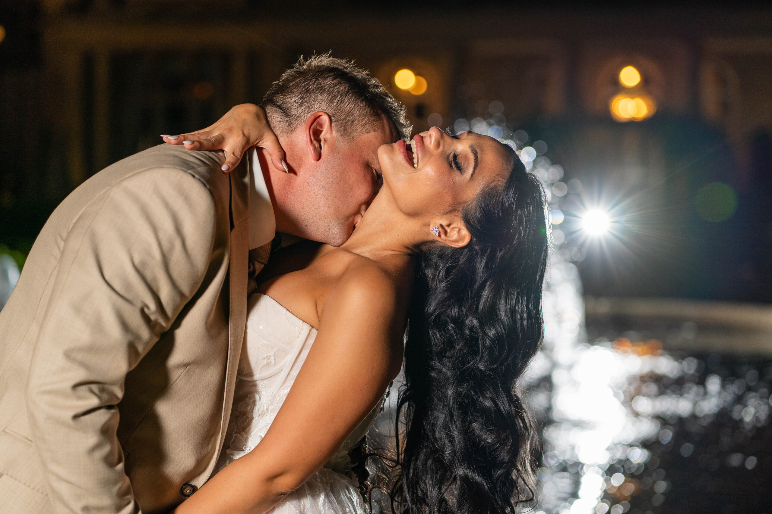 groom kissing bride by the fountain at down hall