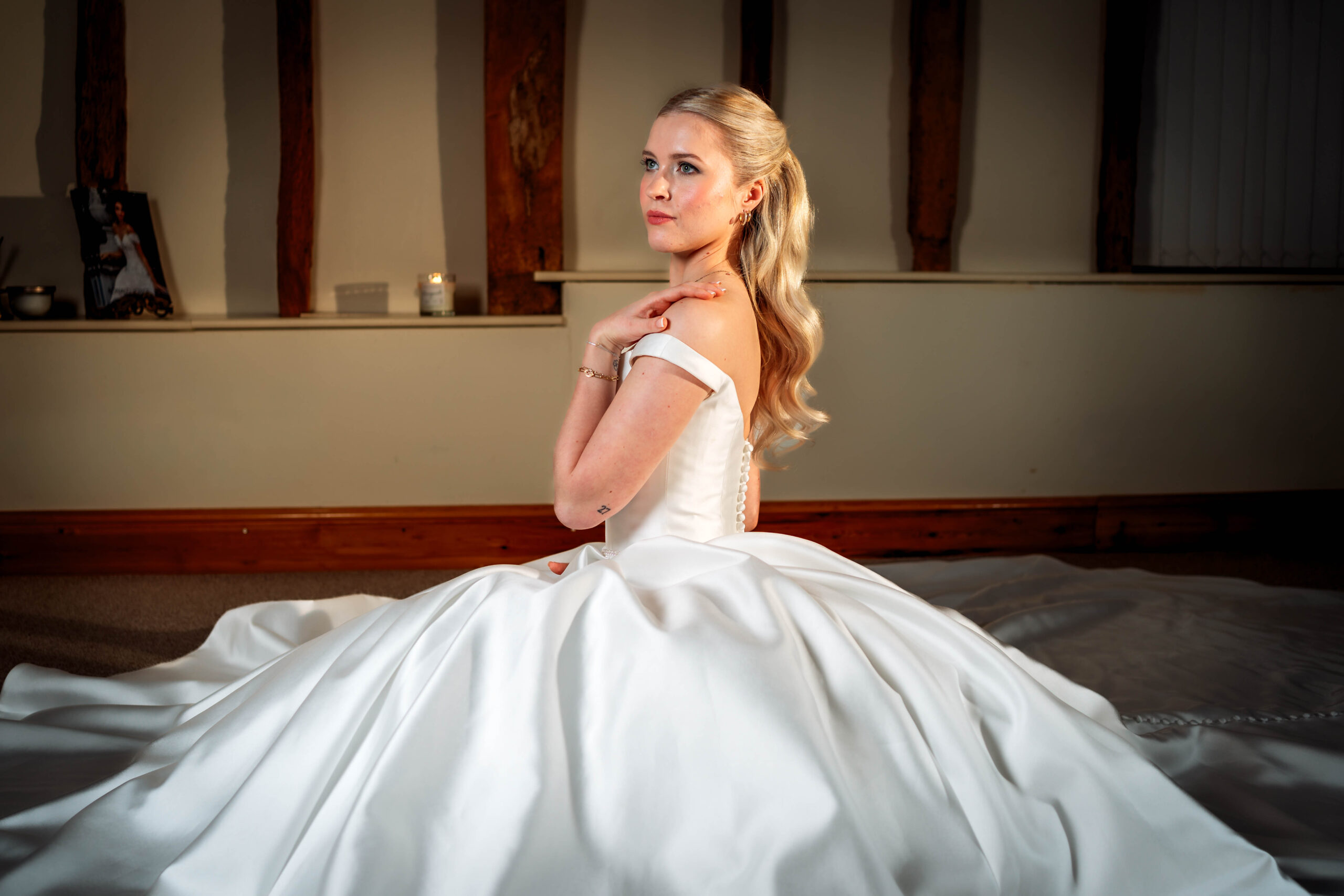 wedding traditions explained - bride sitting on the floor with hand on shoulder posing