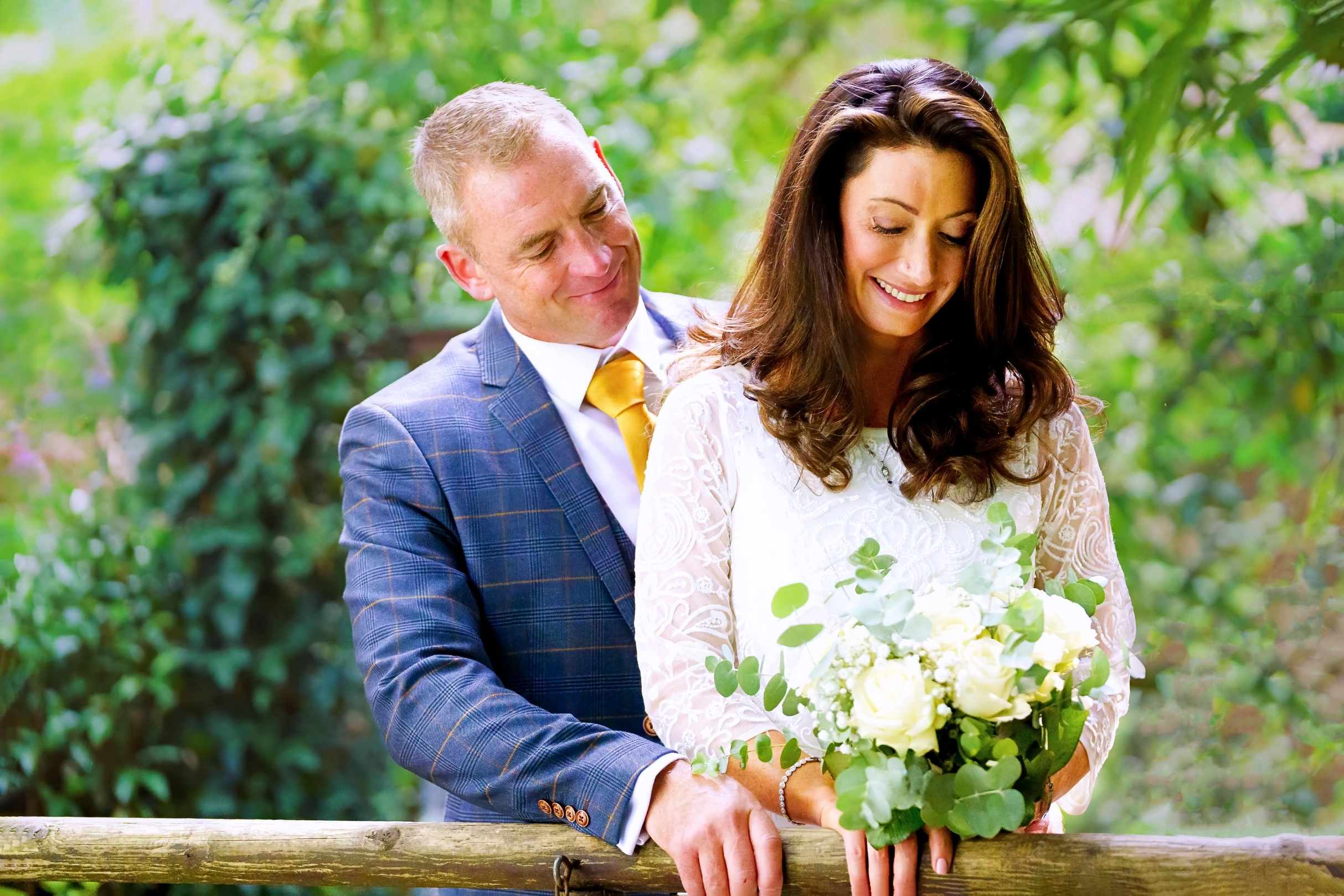 st michaels manor weddings - bride looking at her bouquet whilst the groom looks at bride