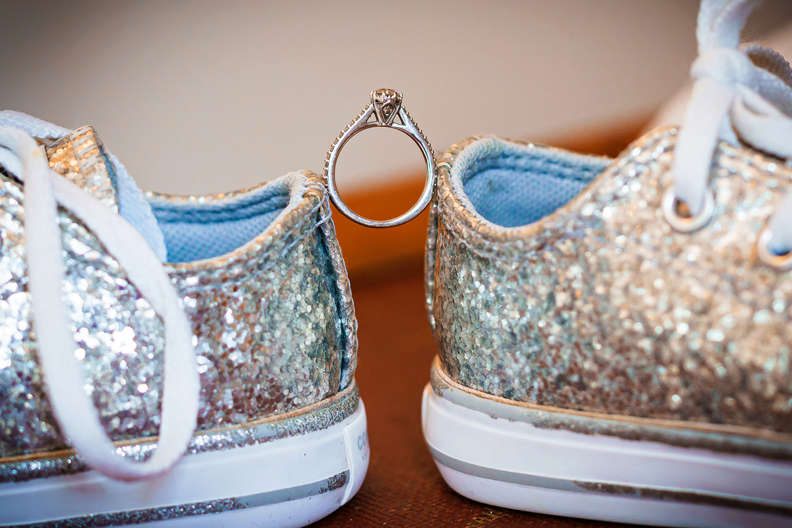 how much does a wedding cost - two sparkly trainers with engagement ring balancing between them
