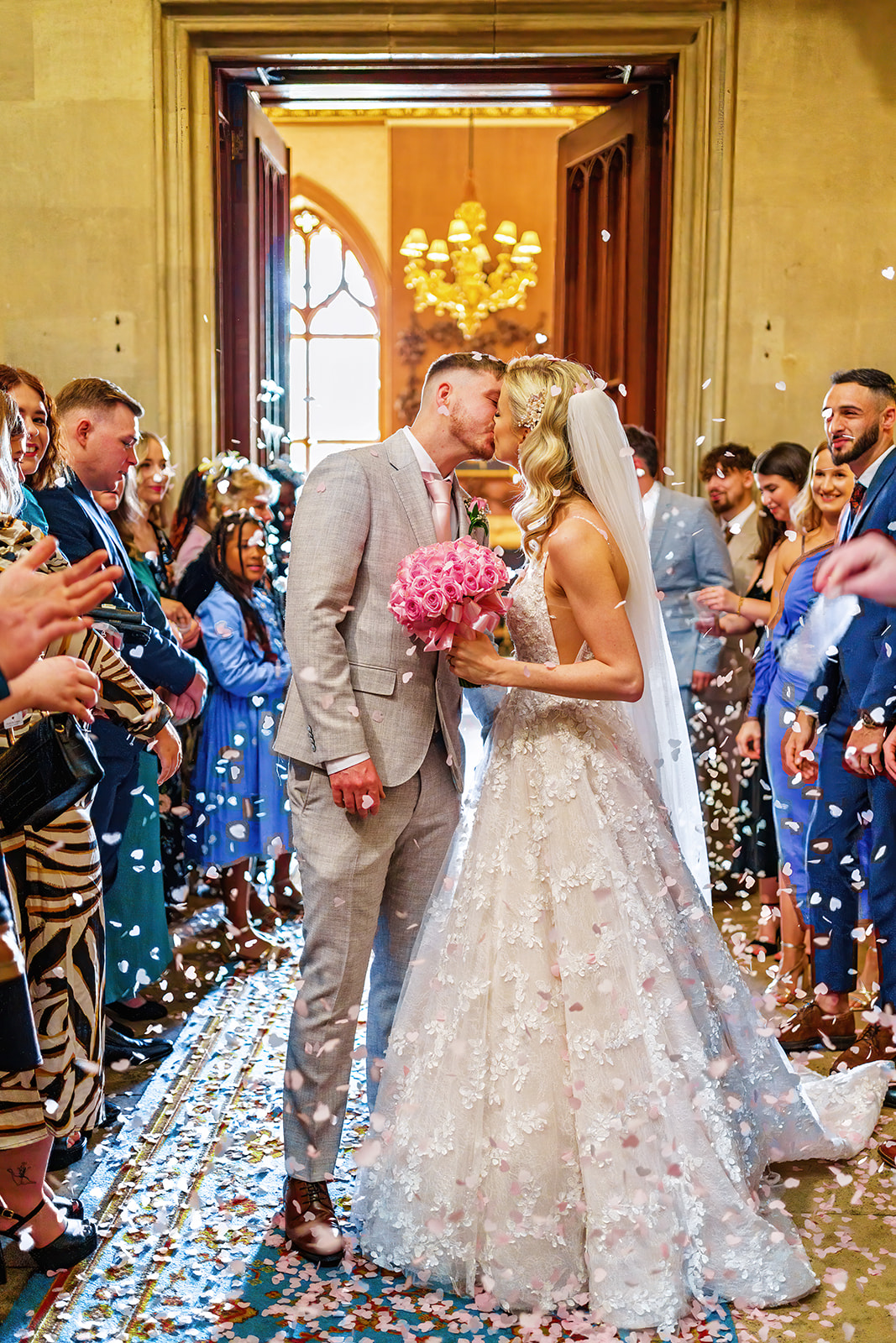 ashridge house - bride and groom kiss under a shower in confetti