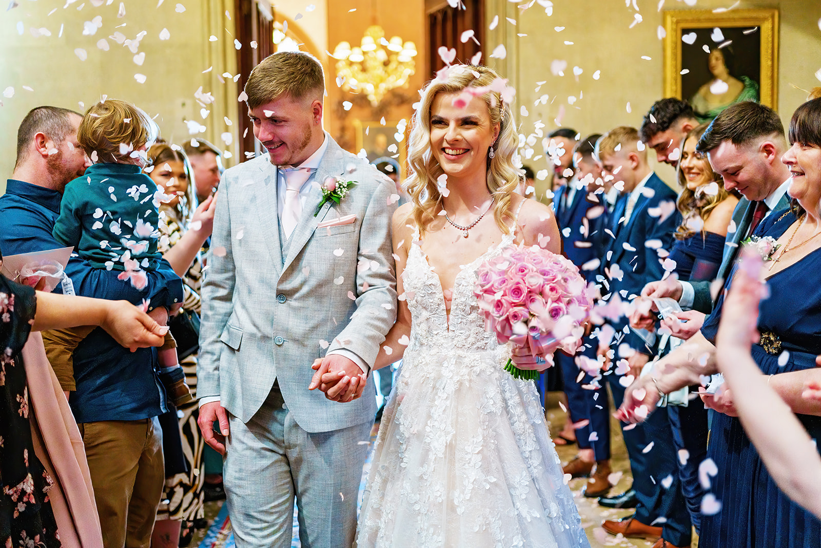 how much does a wedding cost - bride and groom walking through confetti