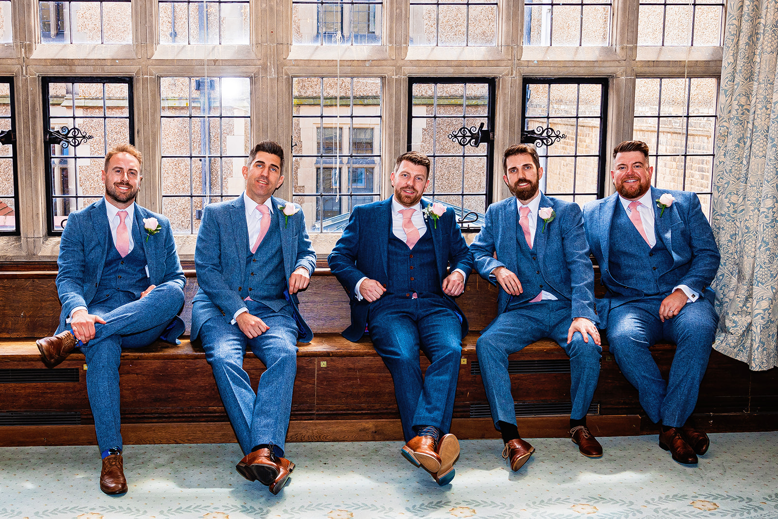 fanhams hall wedding - groom and his groomsmen sitting down, dressed to impress