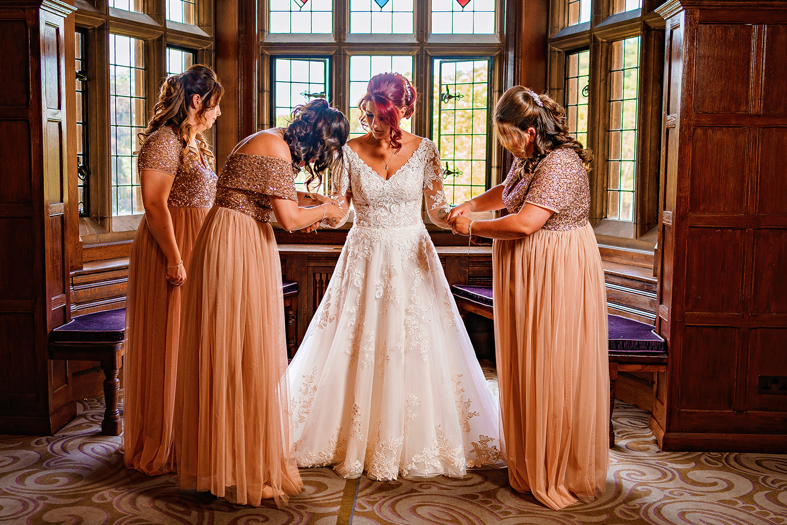 fanhams hall wedding - bridesmaids adjusting brides dress