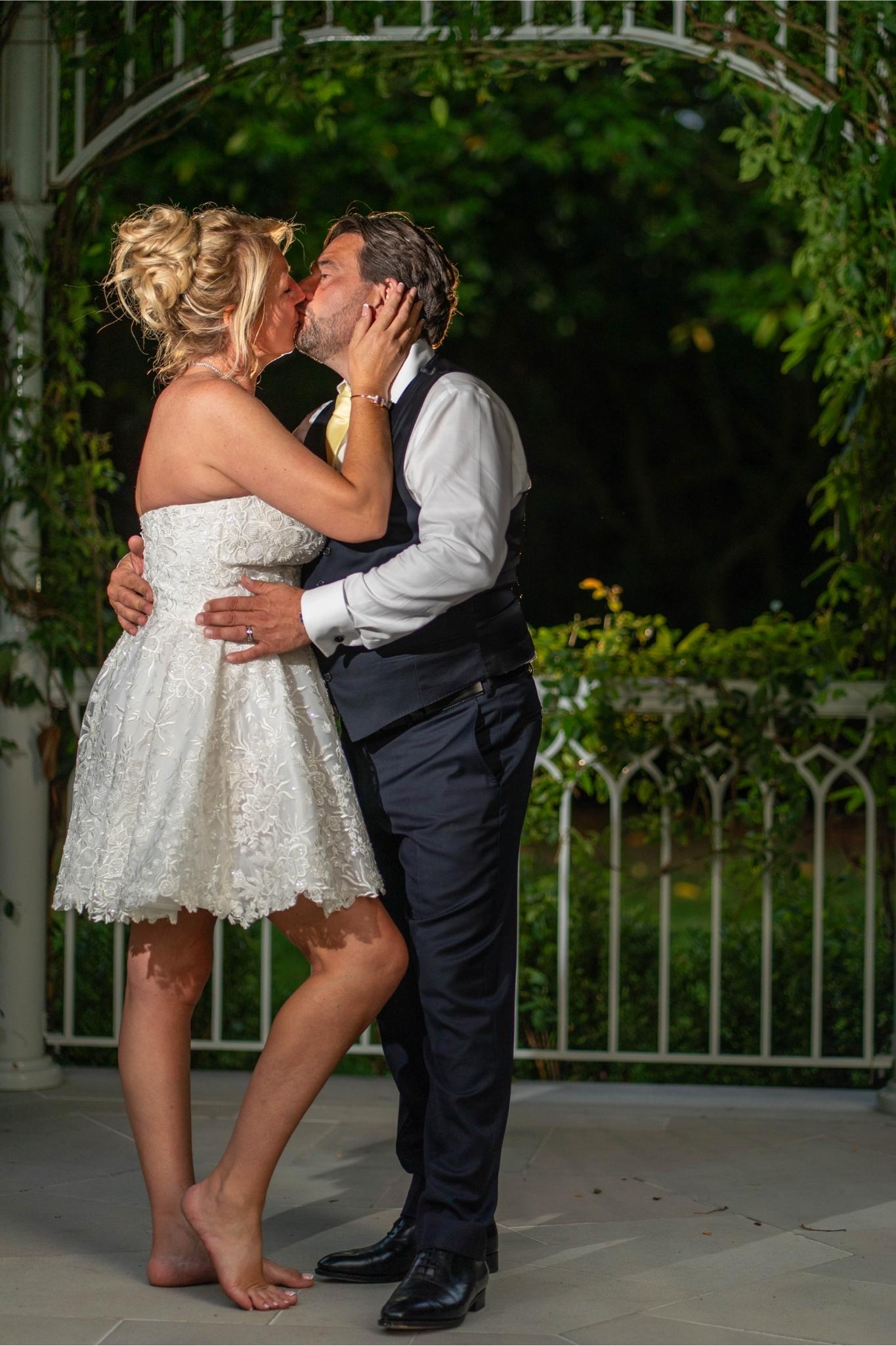 couple kiss at night surrounded by greenery
