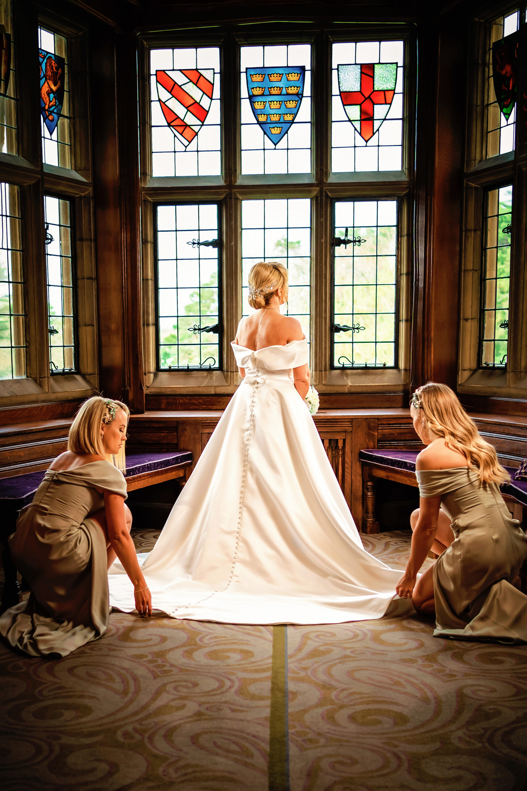 fanhams hall wedding photographer shoots bride looking out of stained glass windows