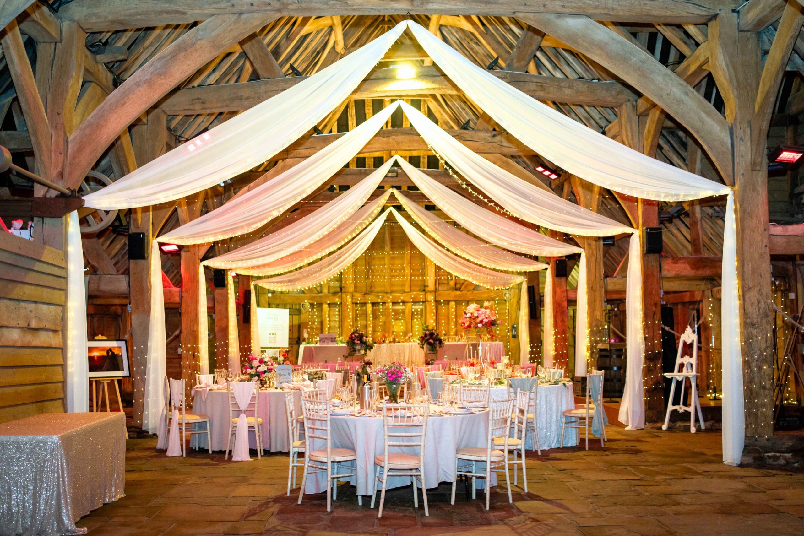 inside of a barn with rounds tables all set up for a wedding