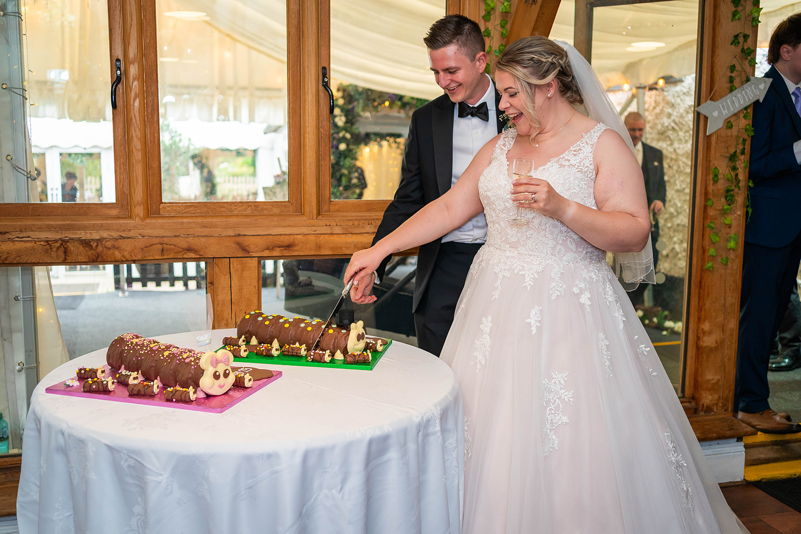 the waterside wedding venue - bride and groom cut their catapiller wedding cakes