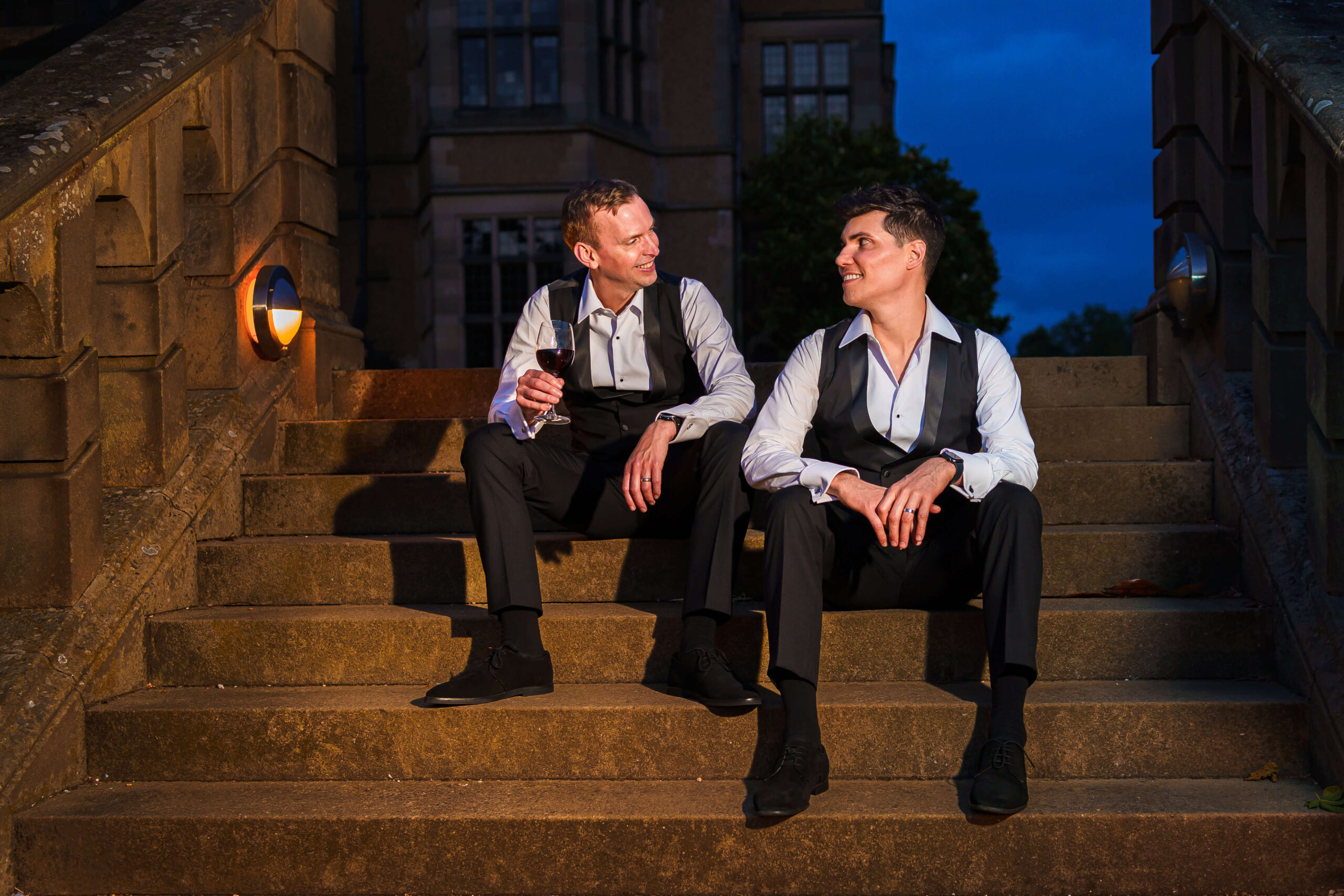 lgbtq+ couple sitting on the steps at night