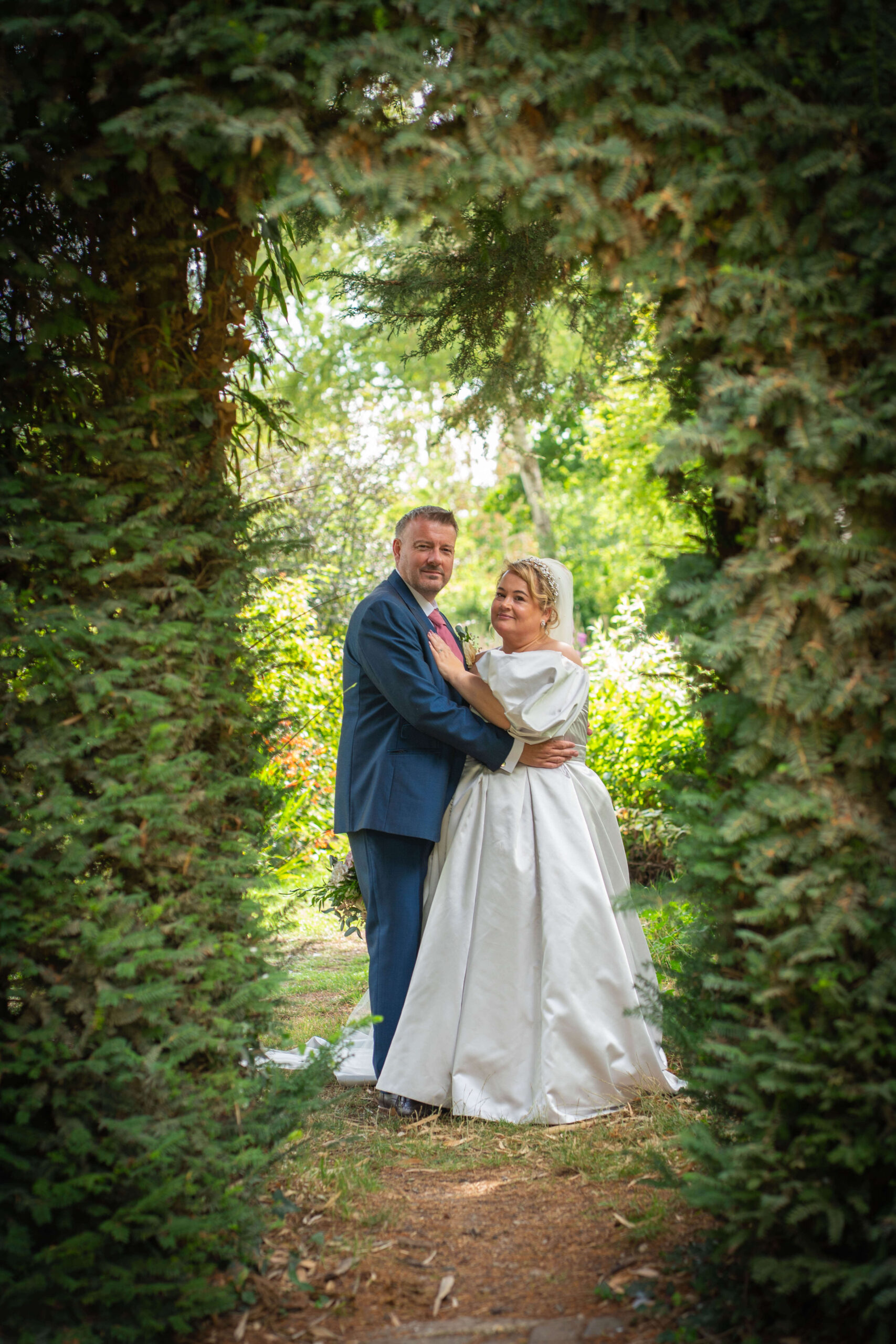 south farm wedding - couples portraits in a tree archway