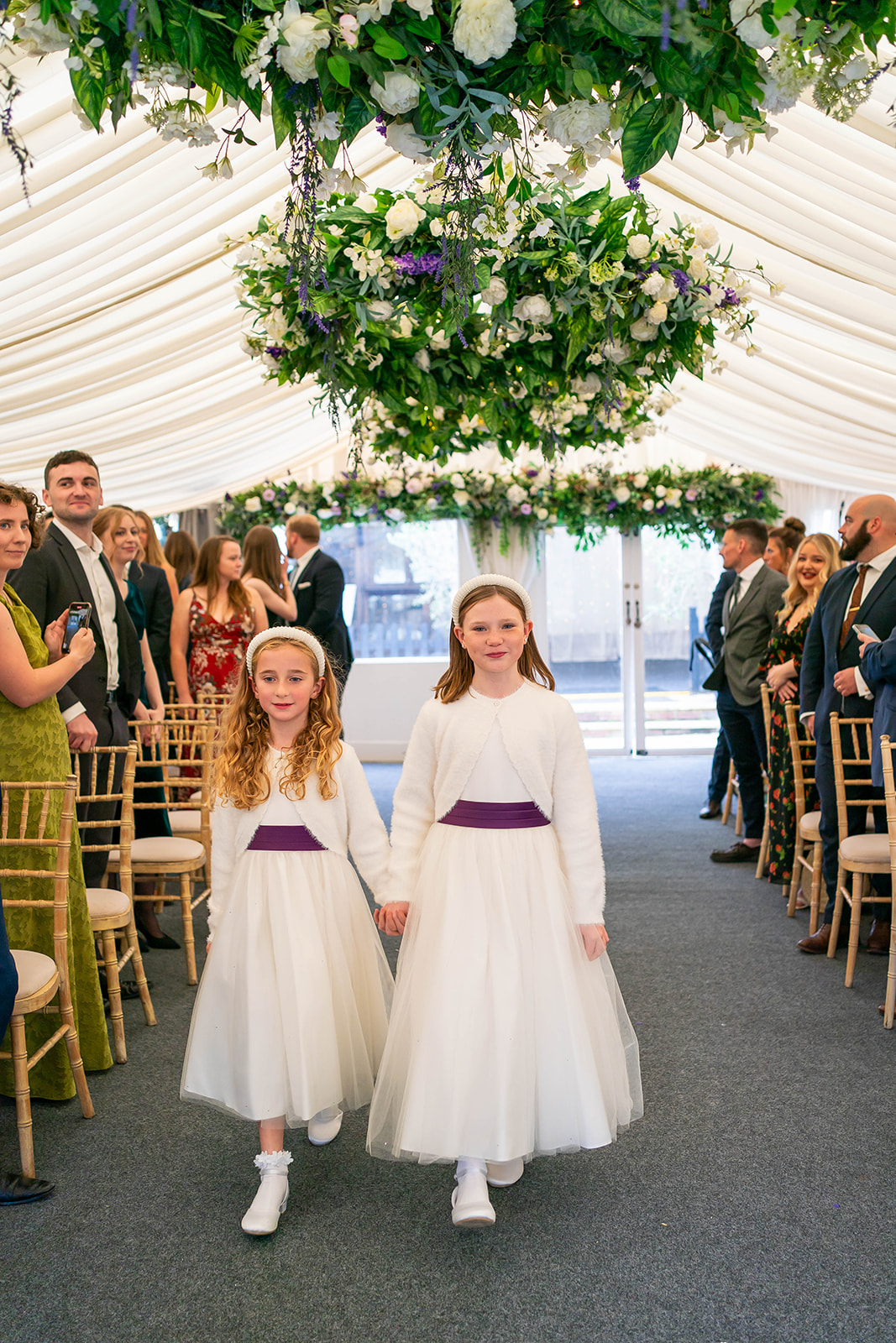 the waterside- two flower girls walk down the aisle