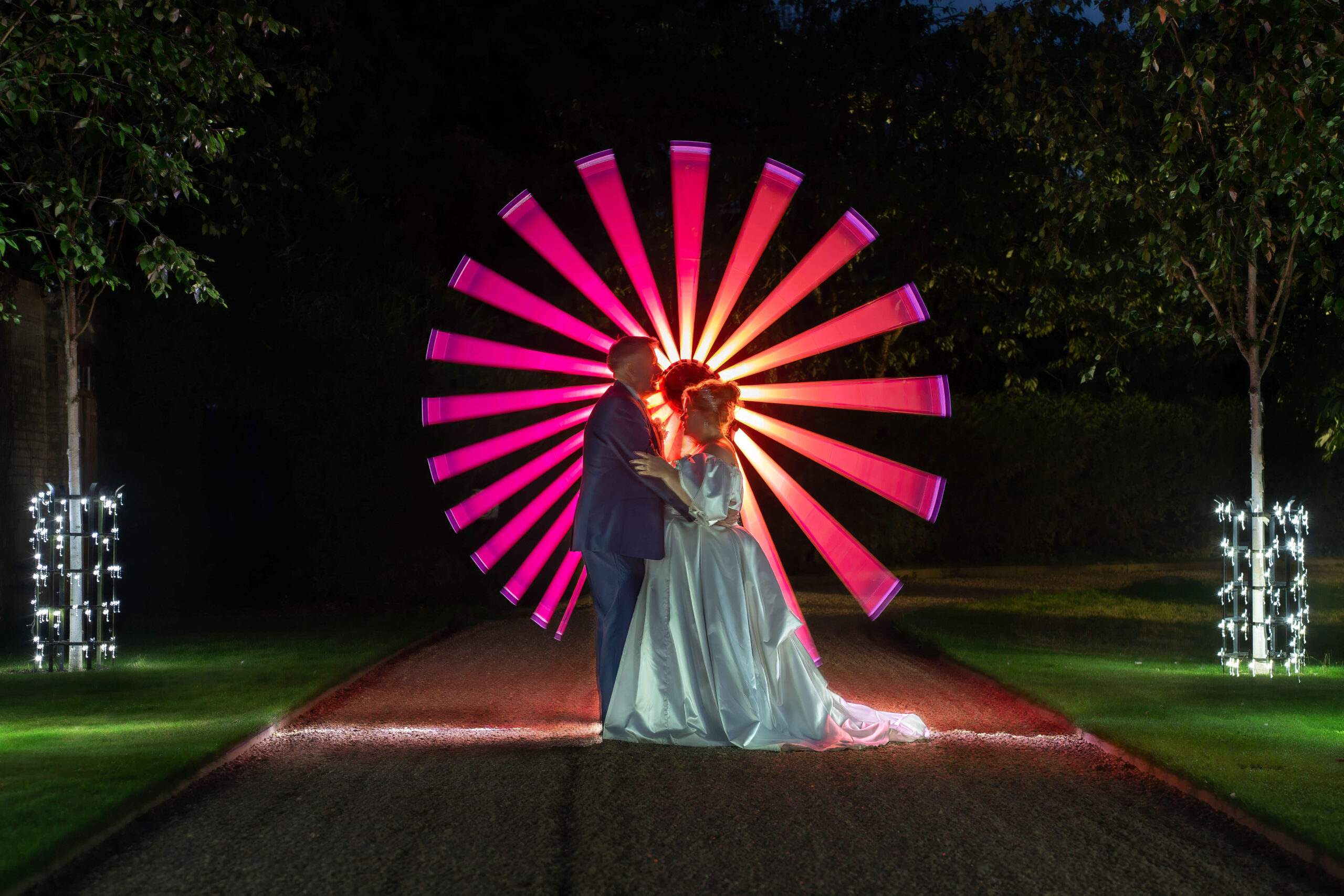 south farm wedding - couple standing in front of a coloured light