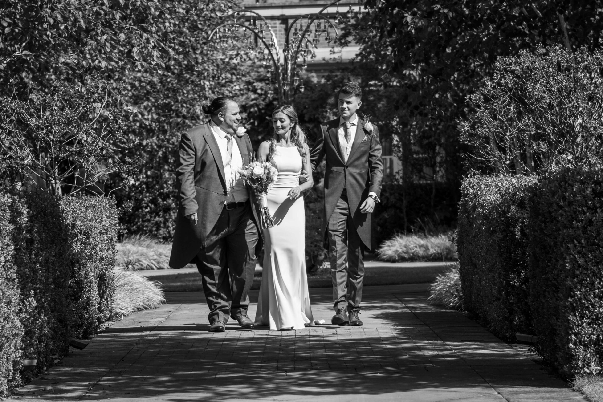 the grove wedding photographer - wedding party walking in the grounds