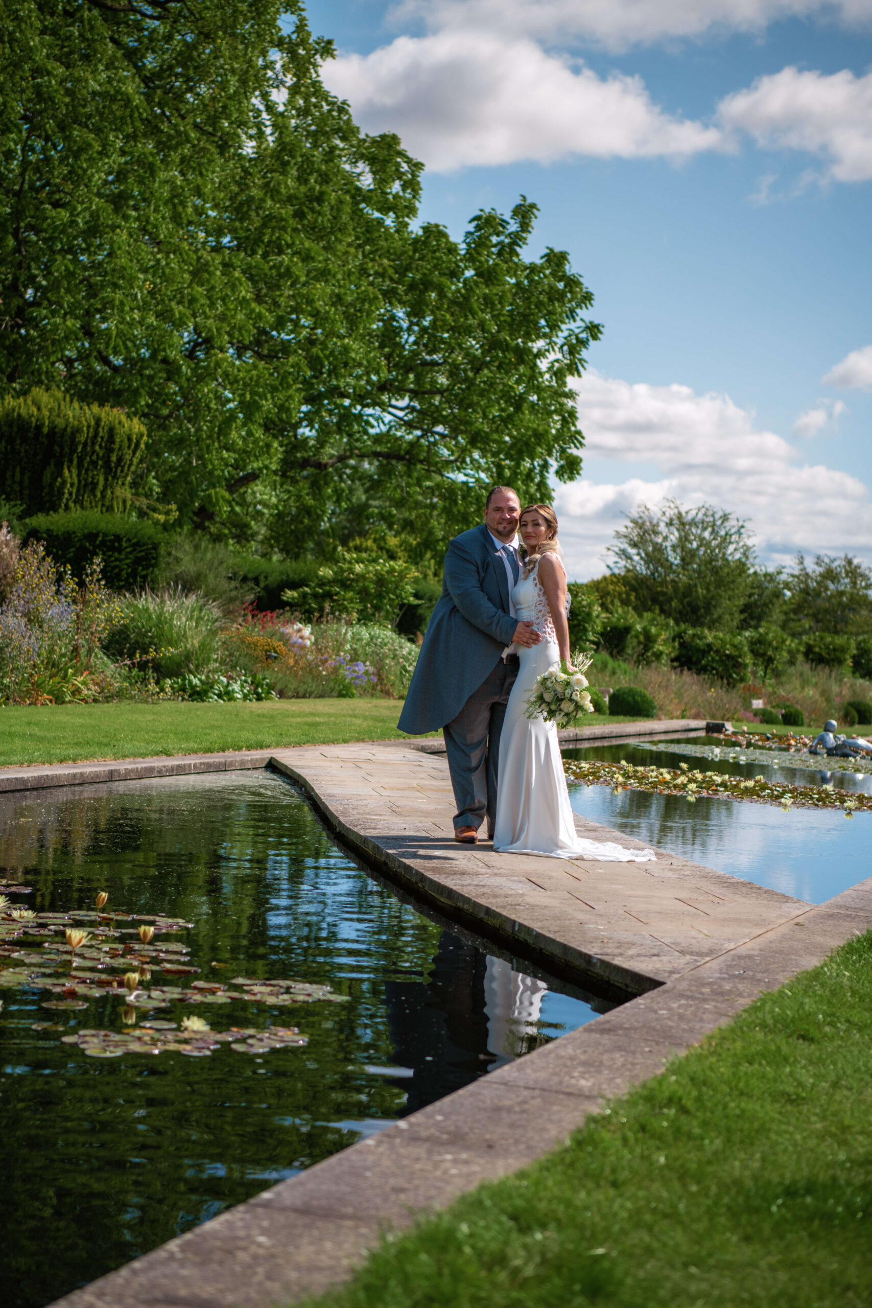 the grove wedding photographer - couple standing on a platform in between the river.