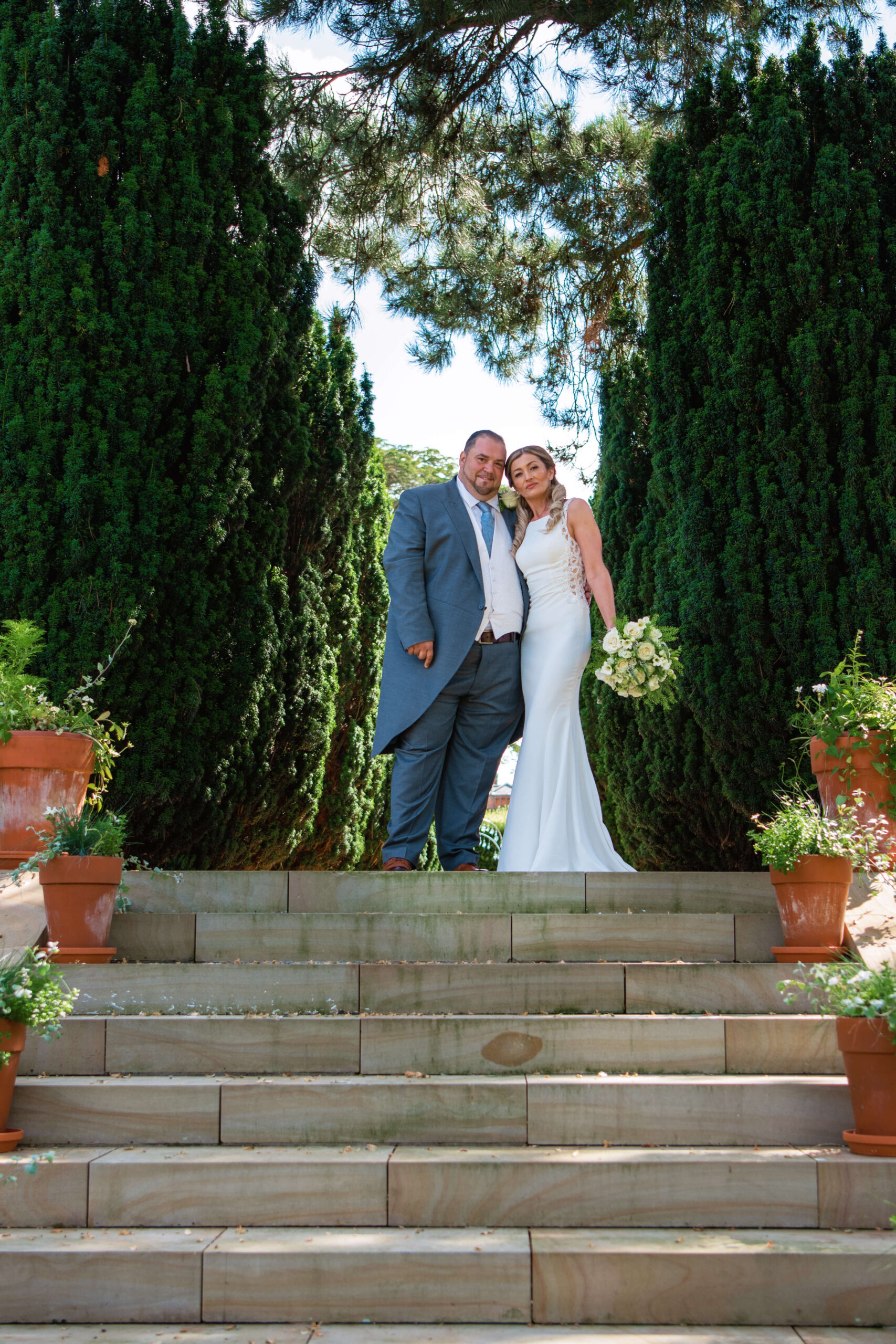 the grove wedding photographer - couple standing in between the trees