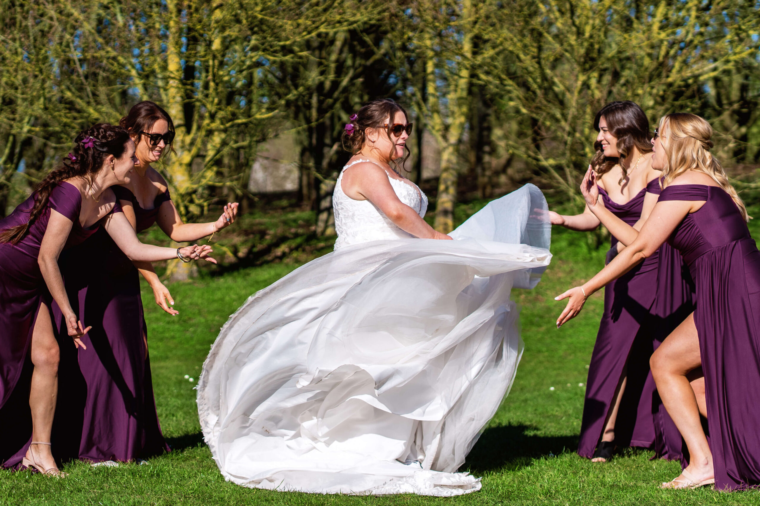 married later in life. the bride swishes her dress as her bridesmaid stand around her