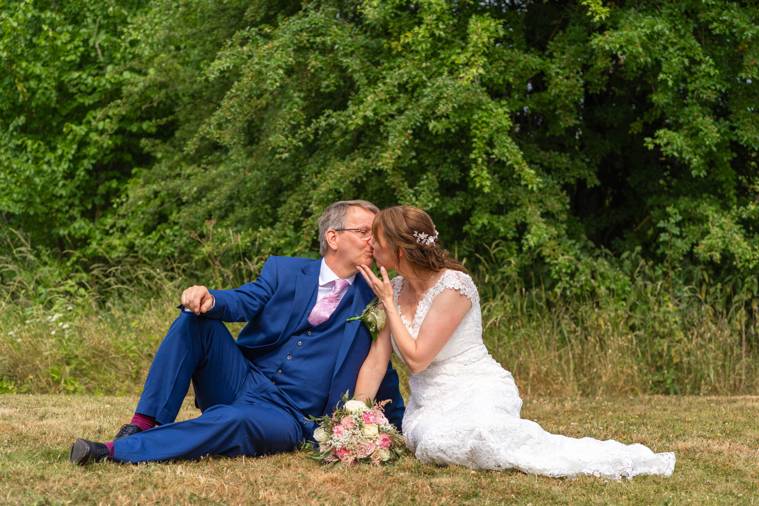 this later in life wedding had the bride and groom sitting on the floor having a kiss