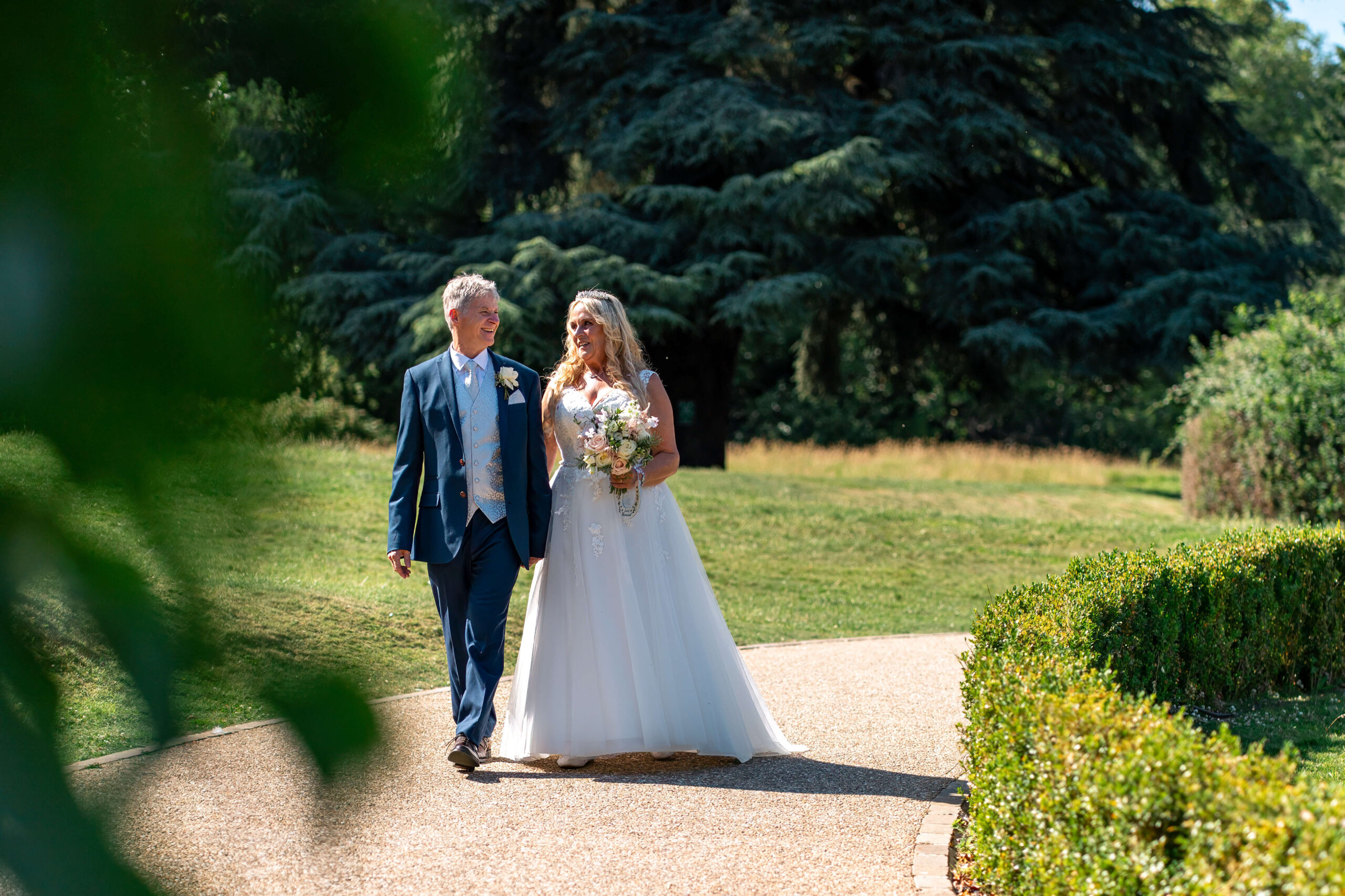 bride and groom walking along the path chatting to one another